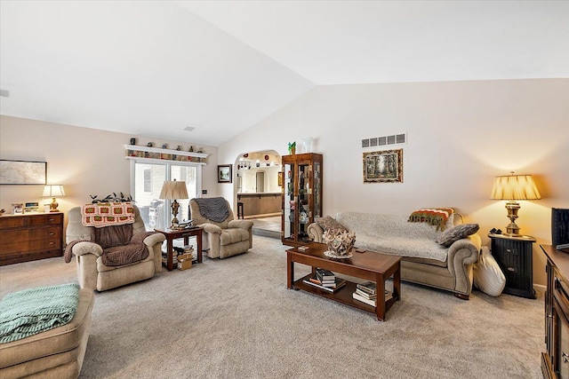 carpeted living room with lofted ceiling