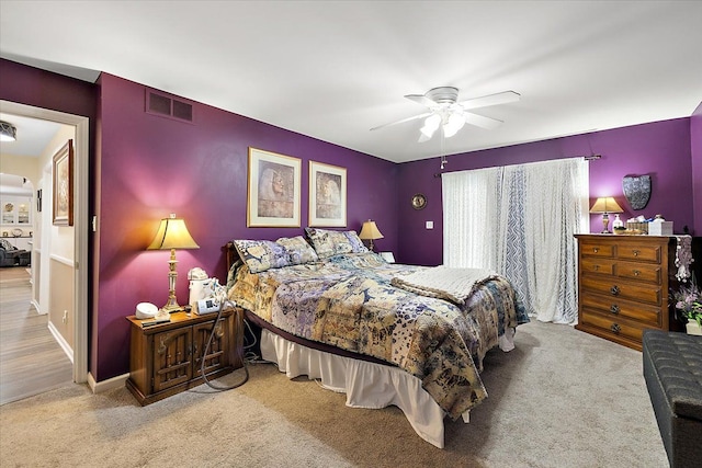 bedroom with ceiling fan and light colored carpet