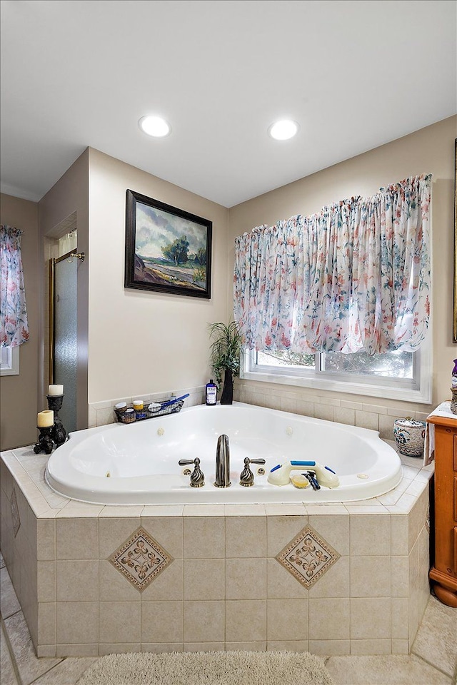 bathroom with tiled bath, tile patterned flooring, and vanity