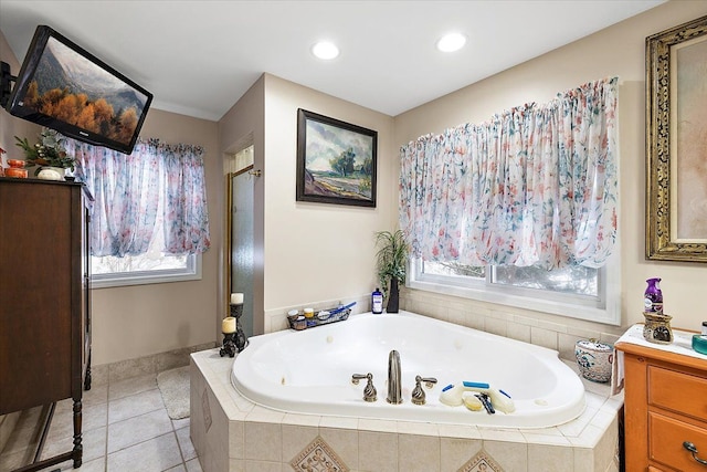 bathroom featuring tile patterned flooring, vanity, and tiled tub