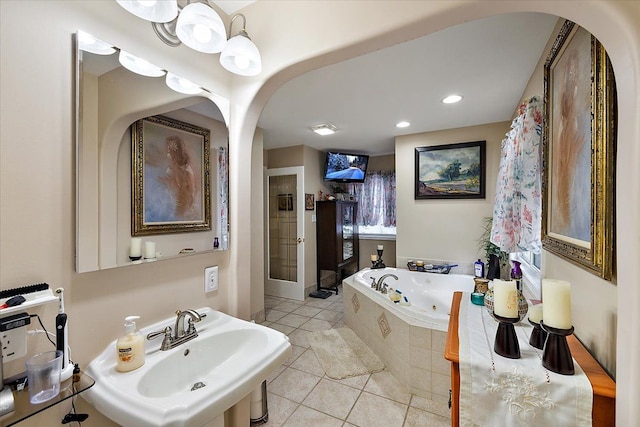 bathroom with tile patterned floors, sink, and a relaxing tiled tub