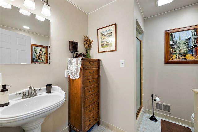 bathroom with tile patterned floors, a shower with door, and sink