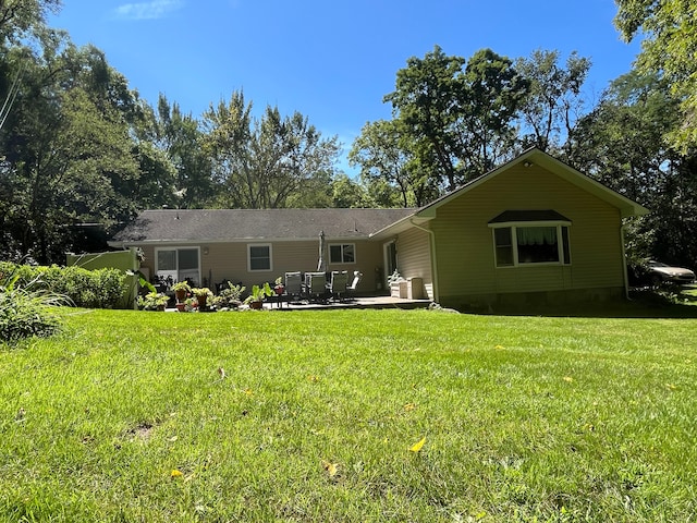 back of house with a patio and a lawn