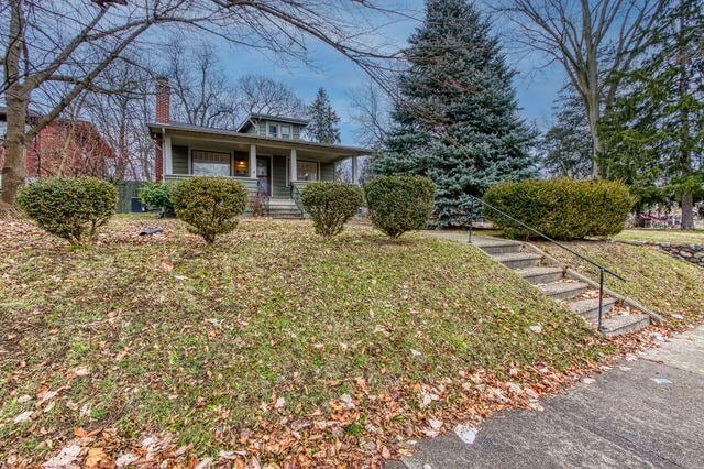 view of front of home with a porch and a front yard