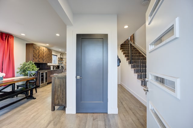 foyer entrance with beverage cooler and light hardwood / wood-style floors