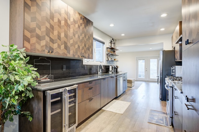 kitchen featuring french doors, light wood-type flooring, tasteful backsplash, stainless steel appliances, and beverage cooler