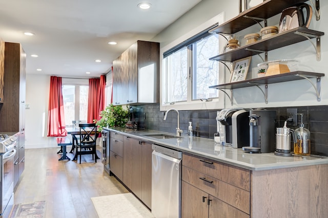 kitchen featuring dishwasher, sink, tasteful backsplash, white range, and light wood-type flooring