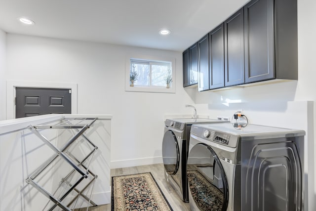 clothes washing area with cabinets and washing machine and clothes dryer