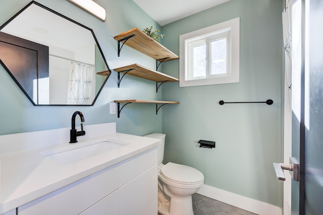 bathroom with tile patterned floors, walk in shower, vanity, and toilet