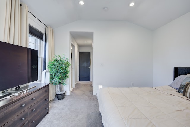 bedroom featuring light colored carpet and lofted ceiling