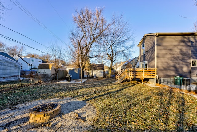 view of yard featuring a shed, an outdoor fire pit, and a wooden deck