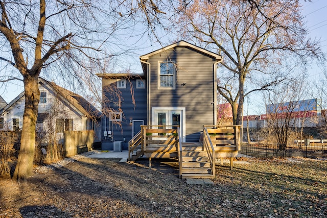 rear view of house with central AC unit and a deck