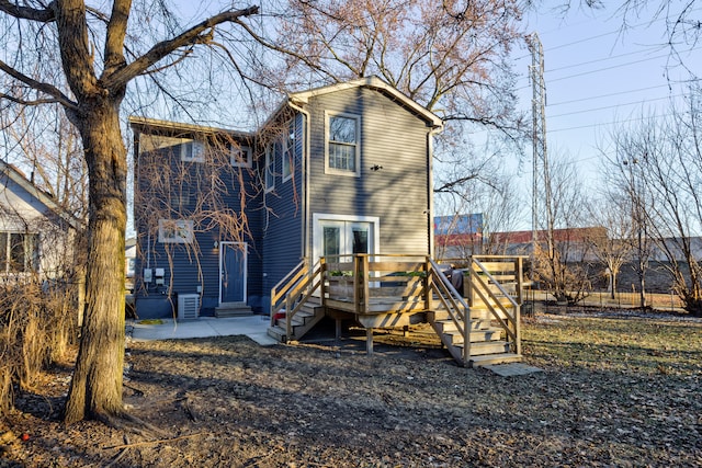 rear view of property with a deck and cooling unit