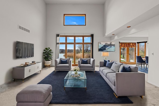 carpeted living room with a wealth of natural light and a high ceiling