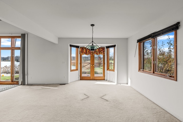 unfurnished dining area with carpet flooring, french doors, and a water view