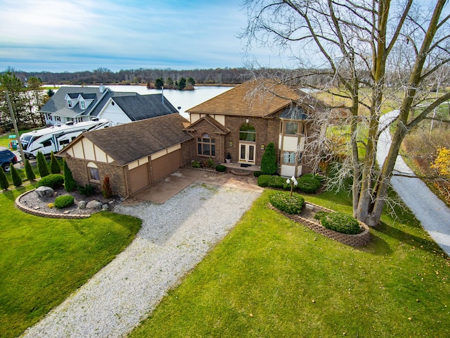 view of front of home featuring a water view, a garage, and a front lawn