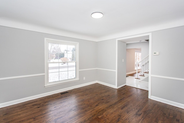 empty room with dark hardwood / wood-style flooring