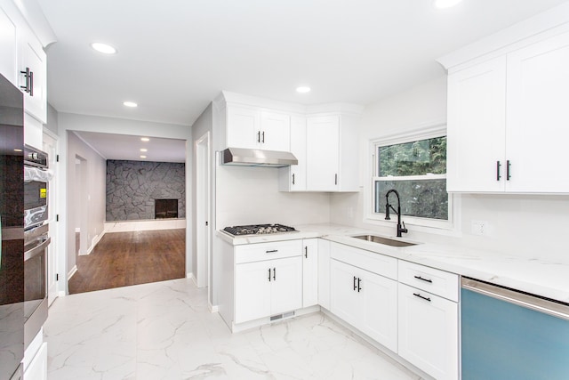 kitchen featuring light stone counters, sink, stainless steel appliances, and white cabinets