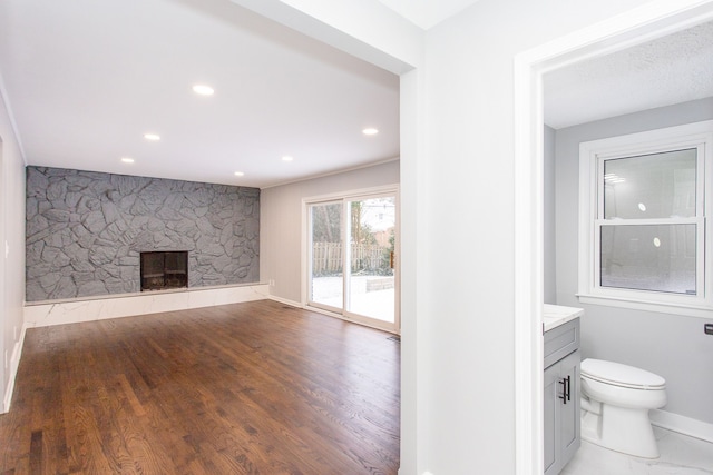 interior space with hardwood / wood-style flooring and a stone fireplace