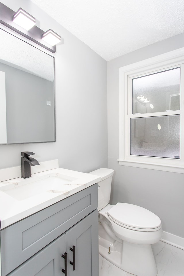 bathroom featuring vanity, a textured ceiling, and toilet