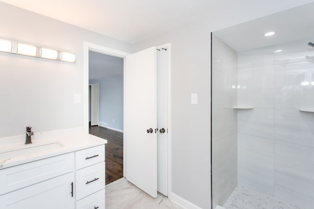 bathroom with vanity and a tile shower