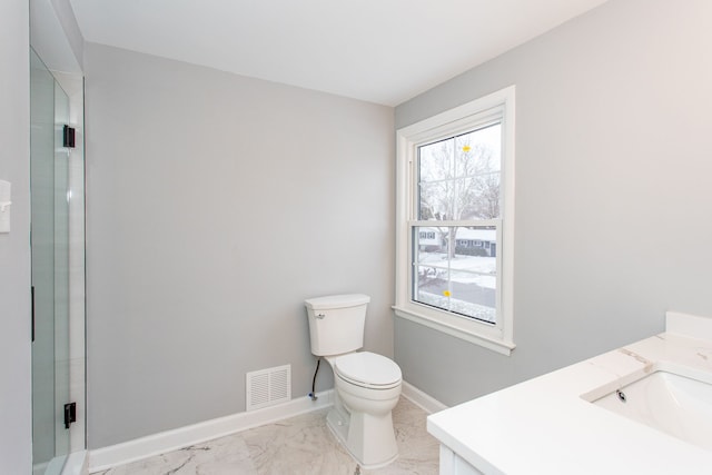 bathroom with vanity, a shower with door, and toilet