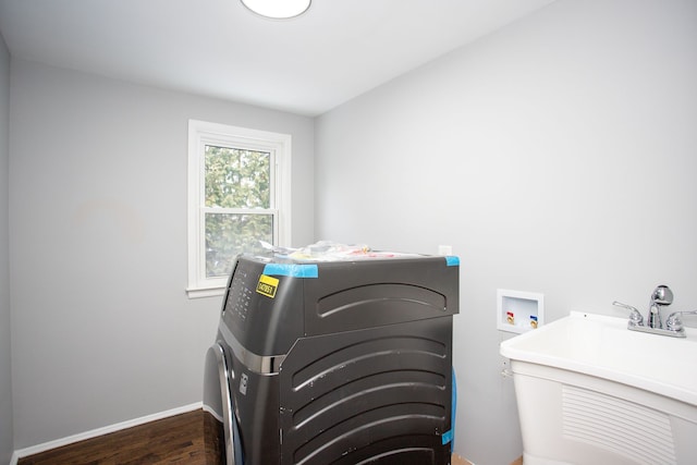 laundry area featuring washer / clothes dryer, dark hardwood / wood-style floors, and sink