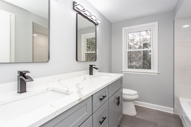 bathroom featuring tile patterned flooring, vanity, a healthy amount of sunlight, and toilet