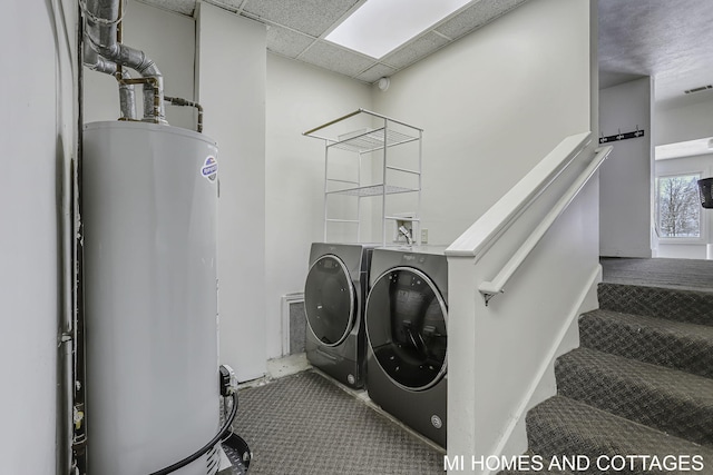 washroom with gas water heater and washing machine and dryer