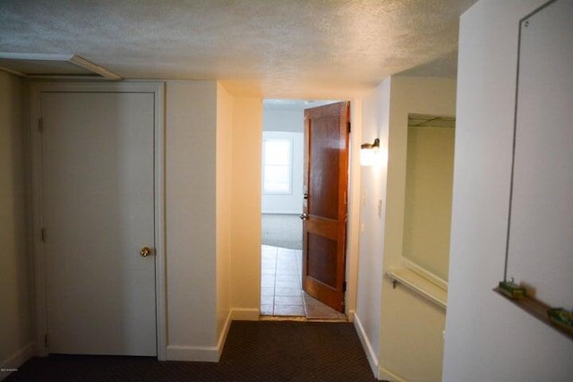 hall featuring carpet floors and a textured ceiling