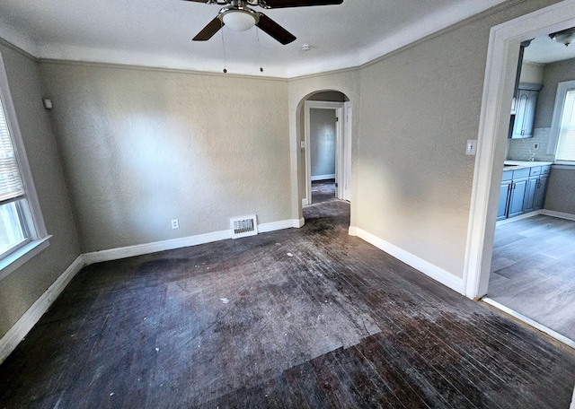 unfurnished room with dark hardwood / wood-style floors, ceiling fan, and ornamental molding