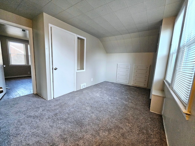 bonus room featuring dark carpet and lofted ceiling