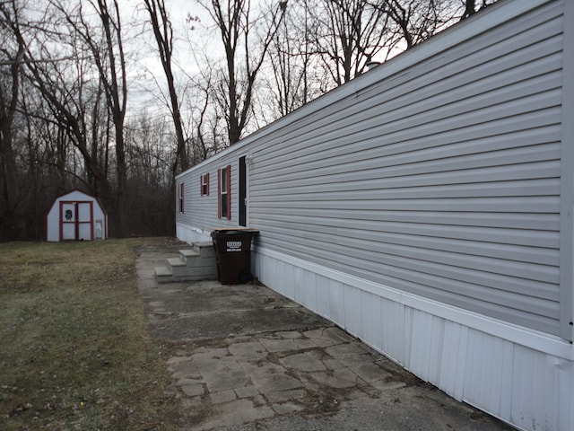 view of side of home featuring a lawn and a shed