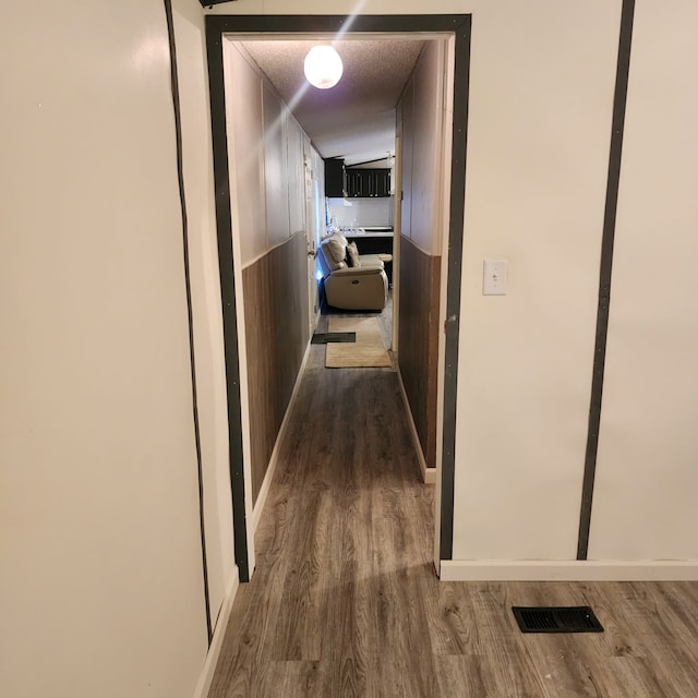 hall featuring hardwood / wood-style flooring and a textured ceiling