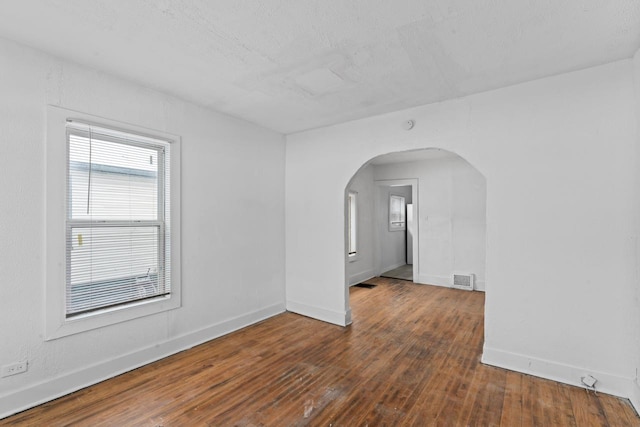 spare room with dark hardwood / wood-style flooring and a textured ceiling