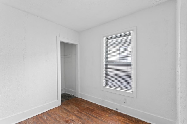 unfurnished bedroom featuring a closet and dark wood-type flooring