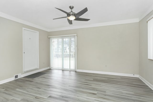 empty room with hardwood / wood-style flooring, ornamental molding, and ceiling fan