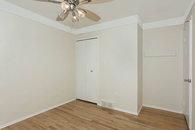 unfurnished bedroom featuring a closet, ceiling fan, and light wood-type flooring