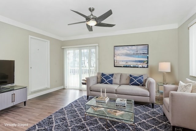 living room with hardwood / wood-style flooring, ornamental molding, and ceiling fan