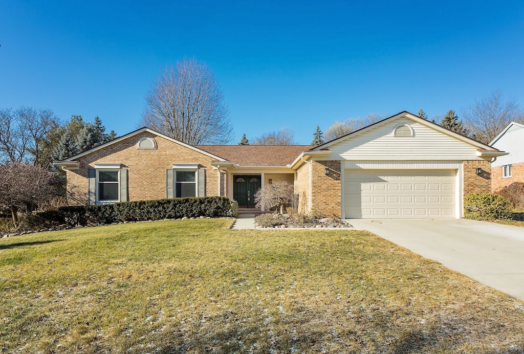 ranch-style home featuring a garage and a front lawn