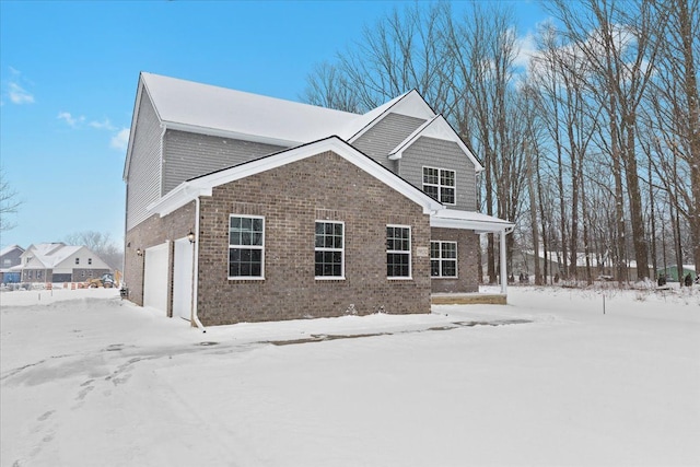 view of snowy exterior with a garage