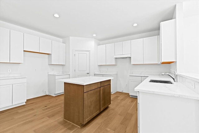 kitchen featuring a center island, light hardwood / wood-style floors, and white cabinets