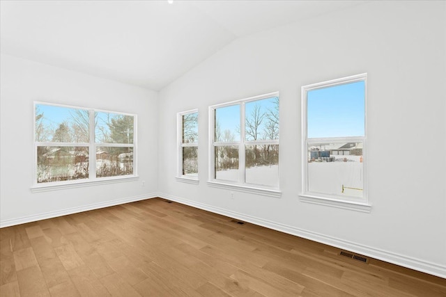 unfurnished sunroom featuring lofted ceiling and plenty of natural light