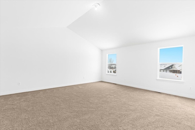 empty room featuring lofted ceiling and carpet