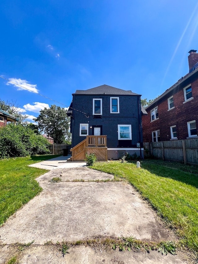 rear view of house featuring a lawn and a patio area