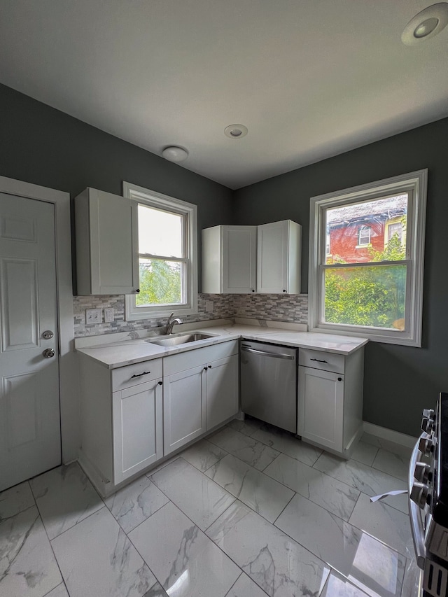 kitchen with backsplash, white cabinetry, sink, and appliances with stainless steel finishes