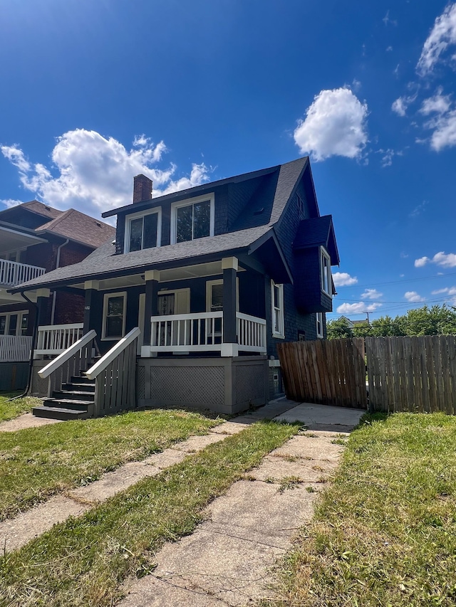 view of front of house featuring covered porch and a front lawn