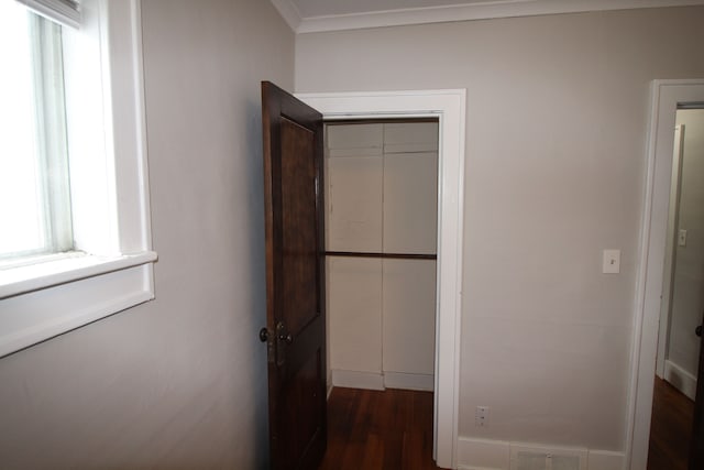 hallway featuring dark hardwood / wood-style floors, a wealth of natural light, and crown molding