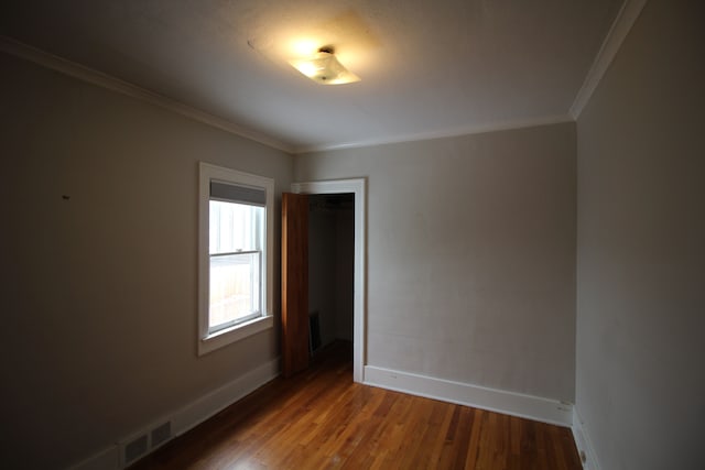 unfurnished room featuring dark hardwood / wood-style floors and crown molding