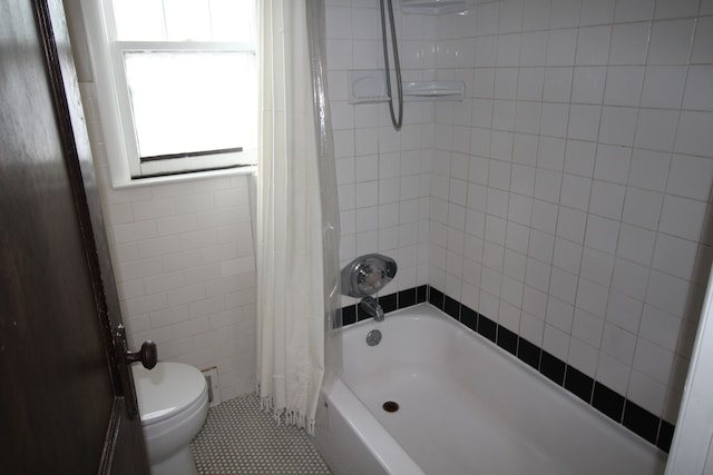 bathroom featuring tile patterned flooring, tile walls, toilet, and shower / tub combo with curtain